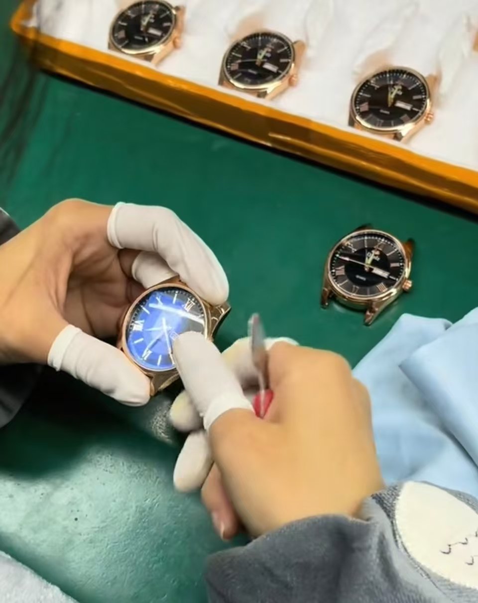 Technician performing final quality control on a watch head and dial