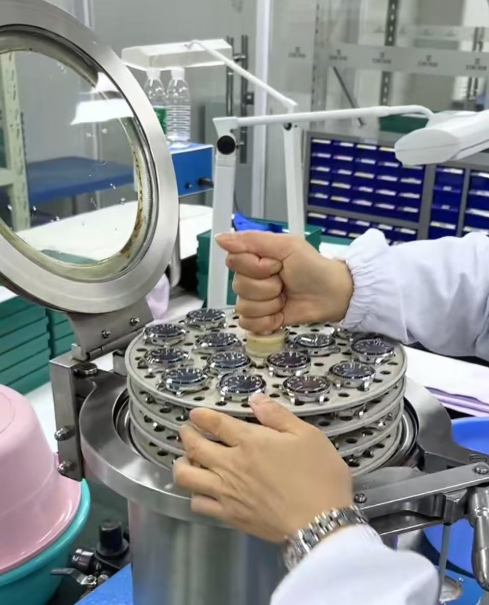Technician loading a watch head into vacuum water-resistance testing equipment